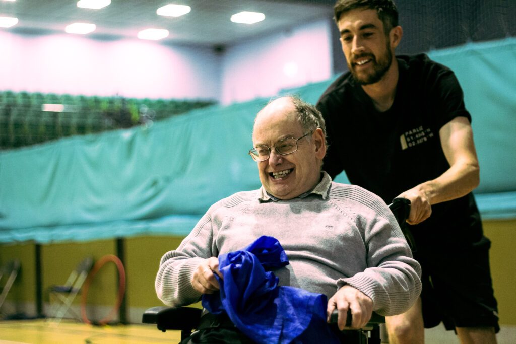 Adult with learning disability being pushed in a wheelchair having fun