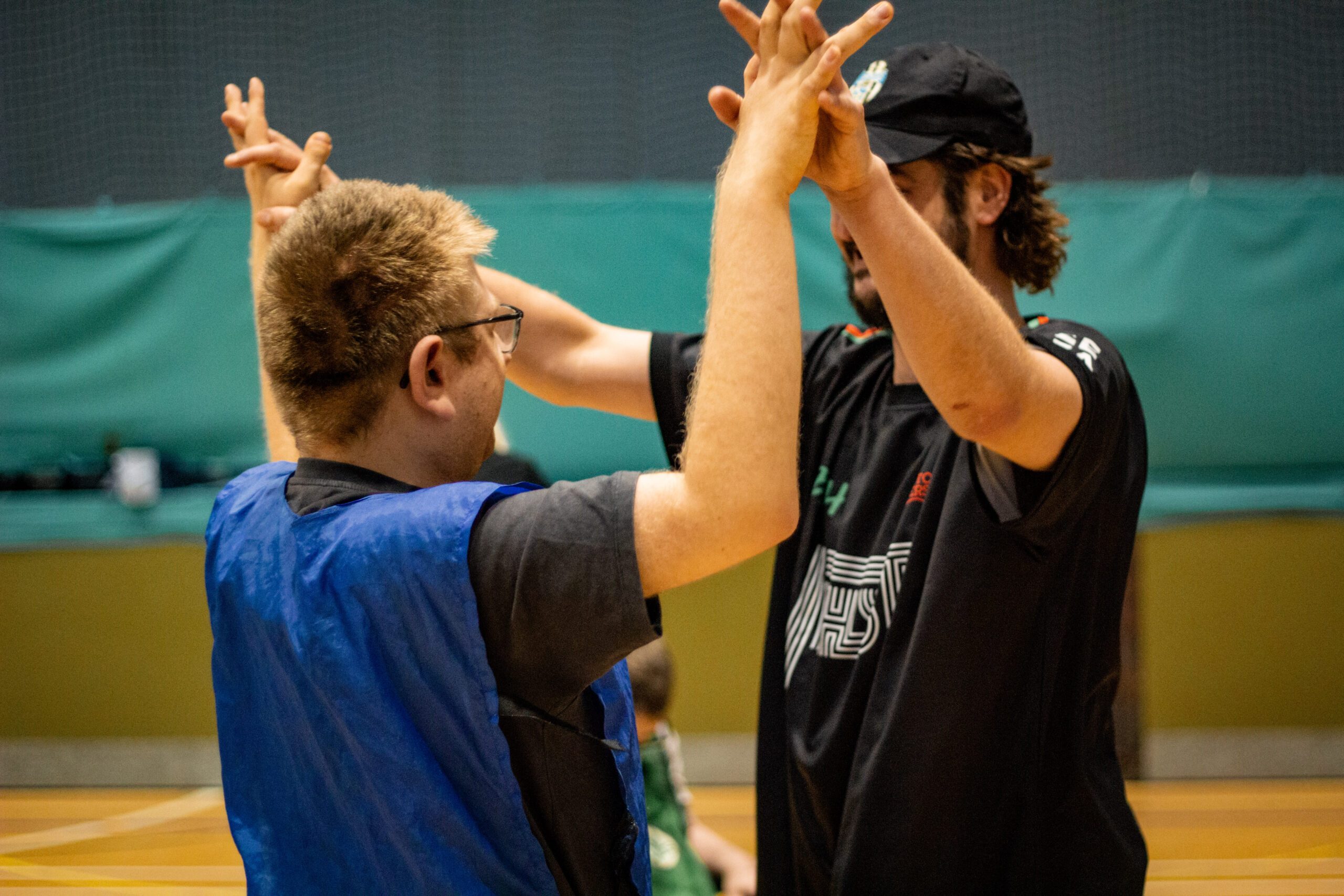 Client with learning disability giving high fives with support worker at Burton Street Foundation in Sheffield
